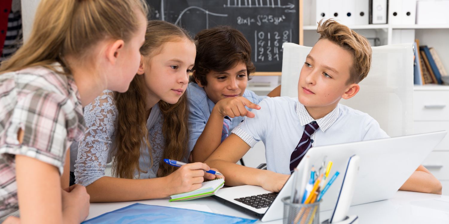 Diákok ülnek körbe egy laptopot és gondolkoznak egy matek feladványon.